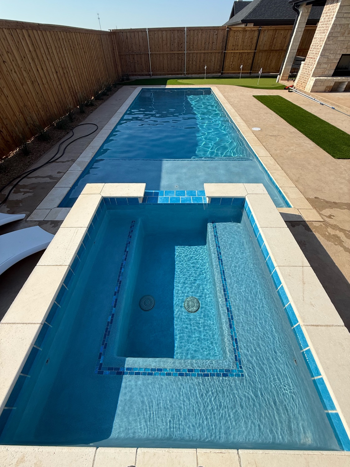 Finished geometric pool and spa with blue glass tile