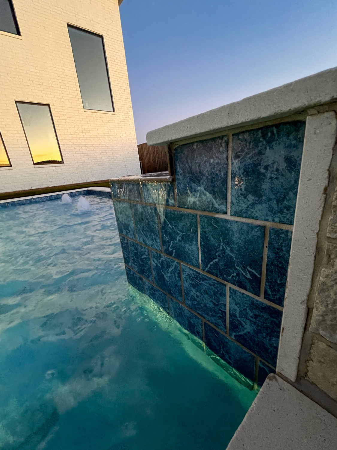 Close view of a blue glass-tile spillway wall on the spa